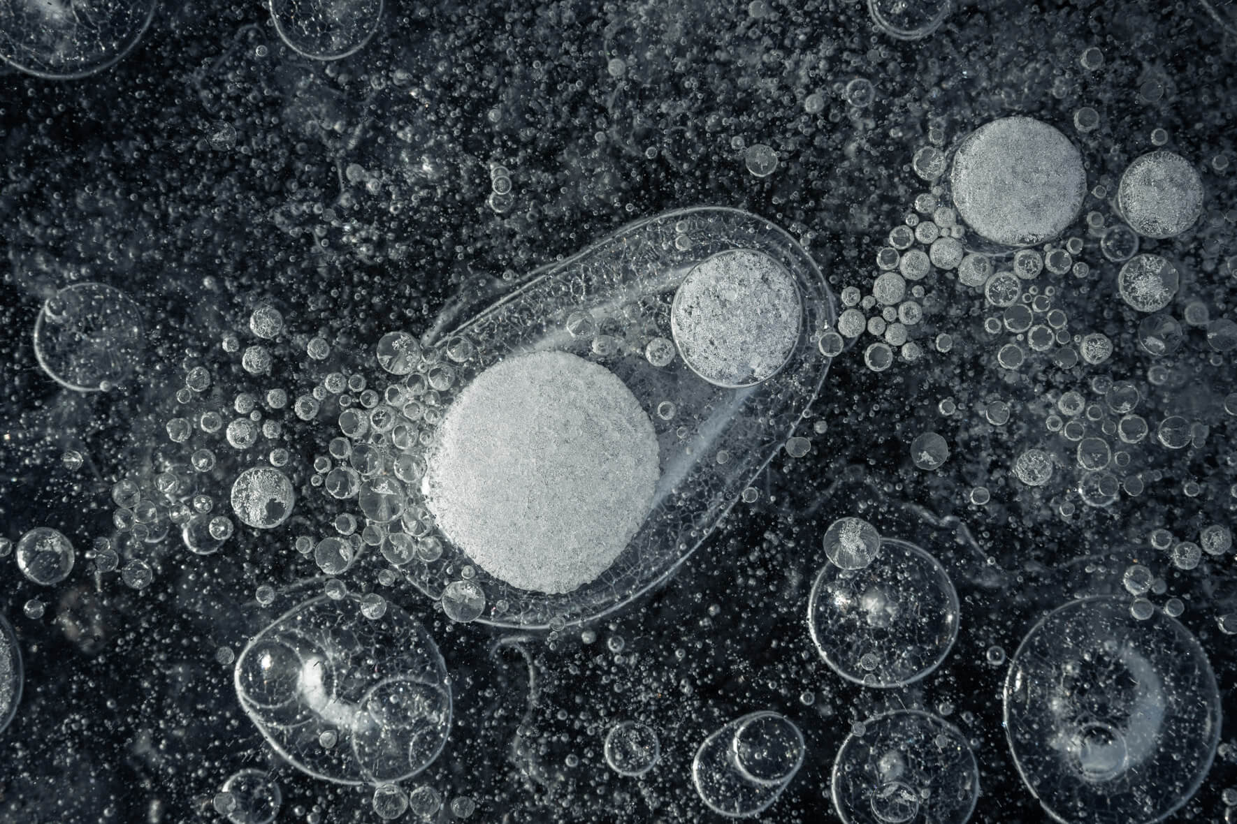 Skaftafellsjökull’s frozen lake with trapped bubbles, displaying icy details