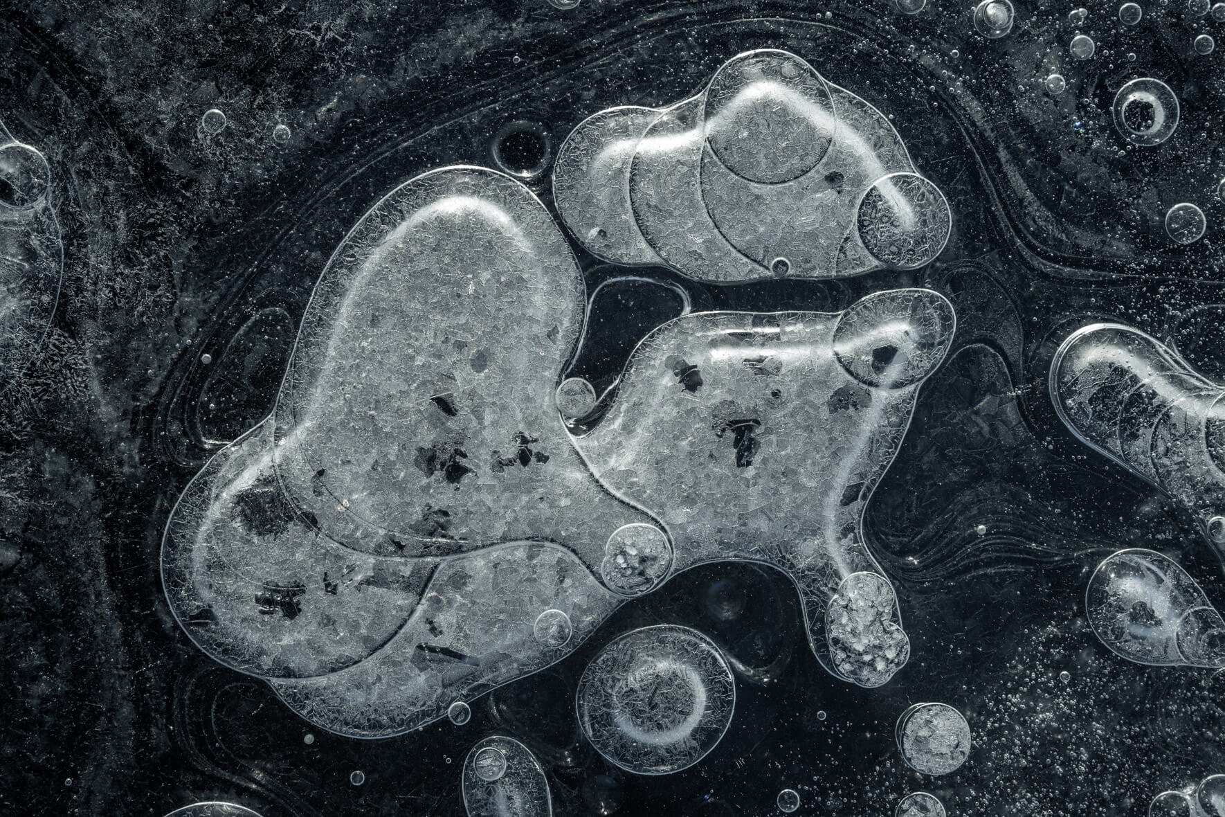 Macro photography of air bubbles in clear black ice