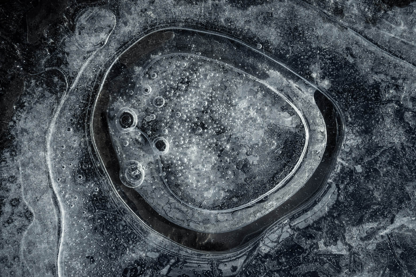 Macro perspective of frozen bubbles in black ice of Skaftafellsjökull glacier in Iceland