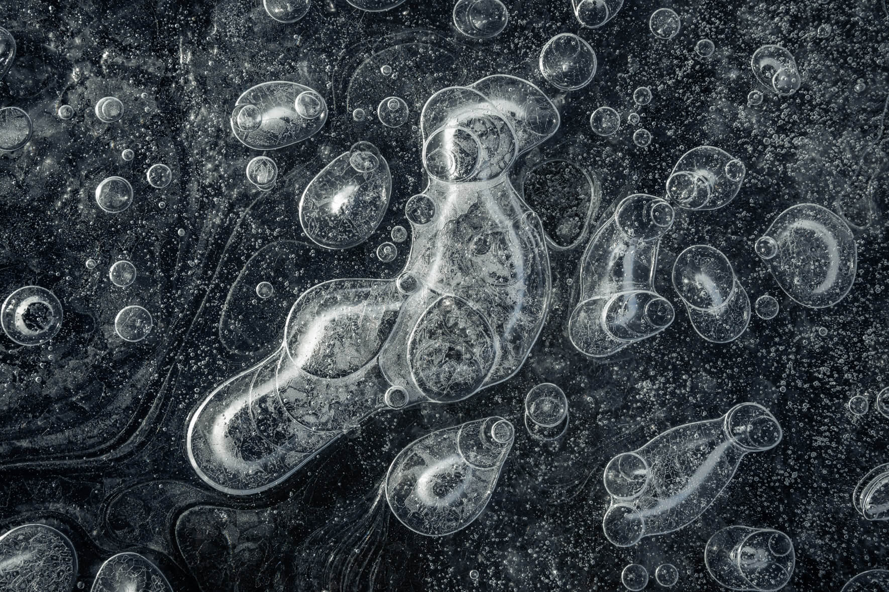 Abstract macro photography of air bubbles trapped in dark glacial ice