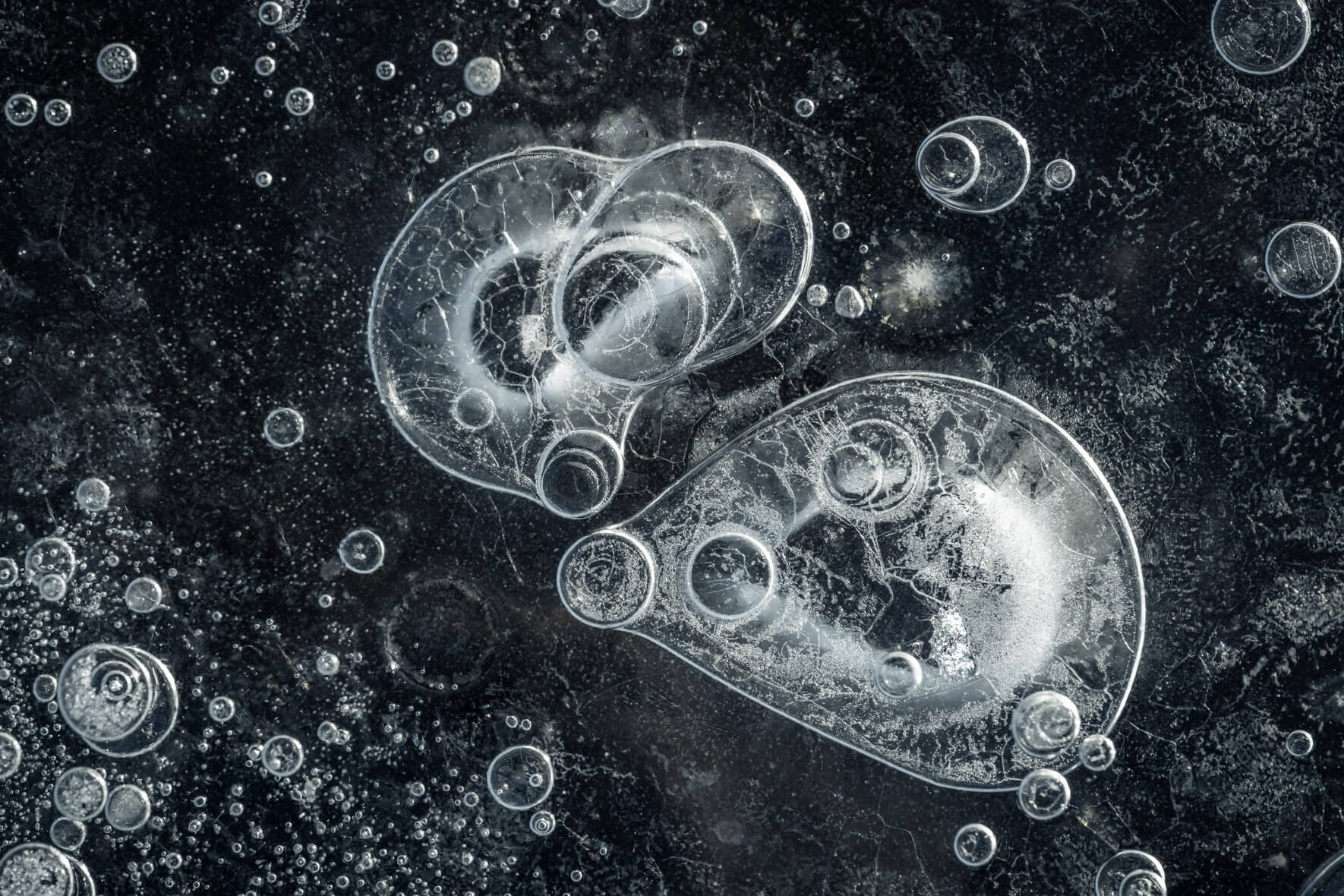 Macro photography of air bubbles in clear black ice in Iceland