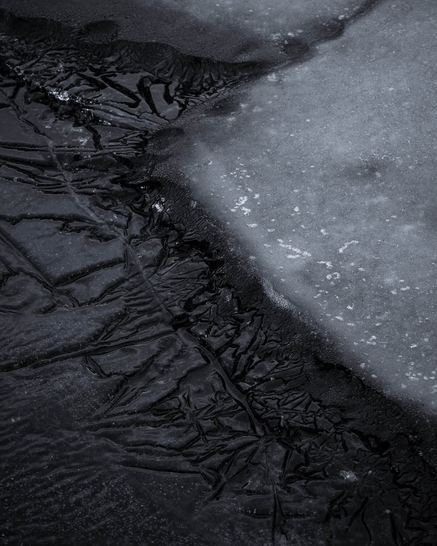 Macro shot of Icelandic lake ice, capturing intricate surface details and fractures in the frozen landscape