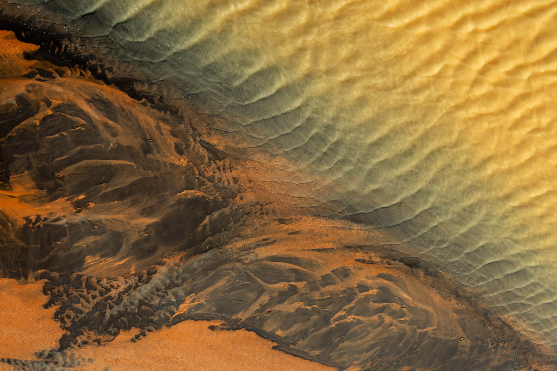 Drone perspective capturing the abstract patterns formed by sulphur deposits in an Icelandic river