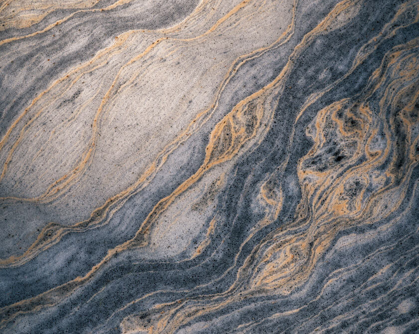 Swirling natural formations of tree pollen on a Norwegian stream’s surface