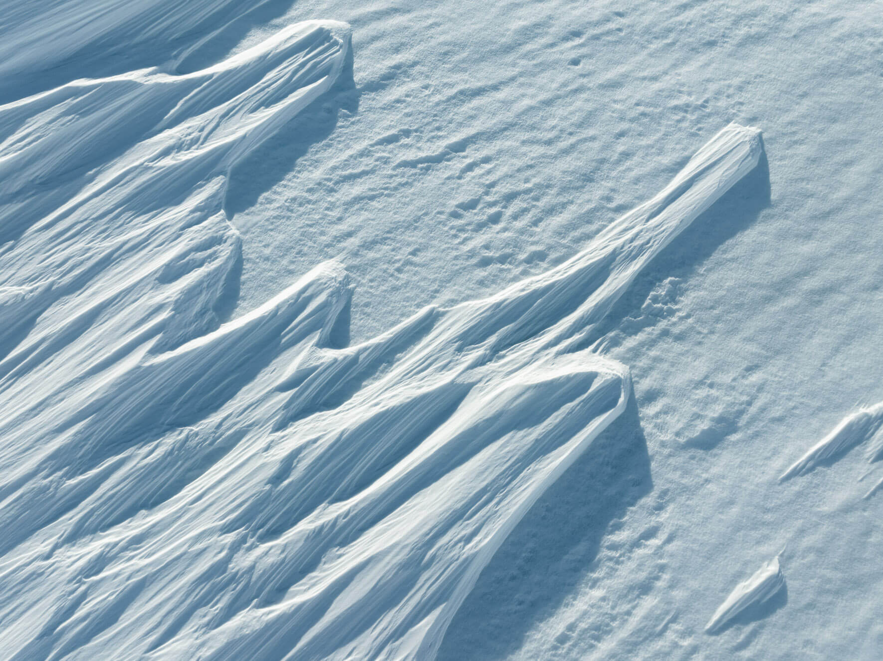 Close-up aerial view of delicate snow ridges shaped by powerful winds in Hardangervidda