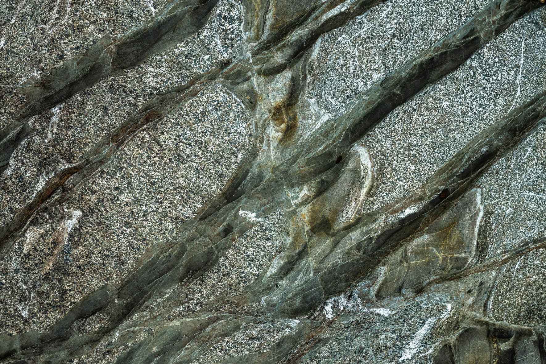Rock surface with rhythmic mineral bands and light oxidation marks
