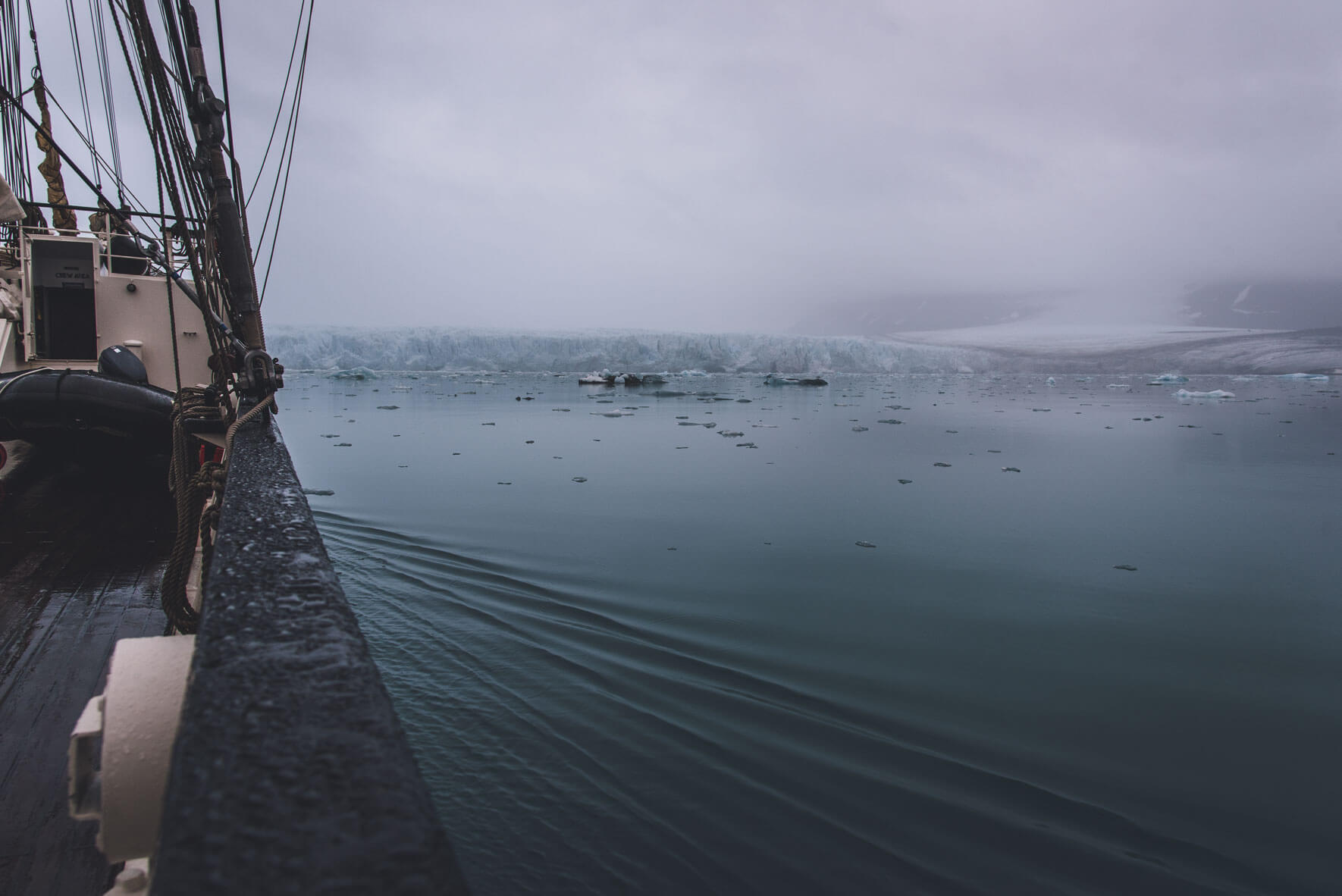 Three-mast sailing ship Antigua and glacier on Svalbard