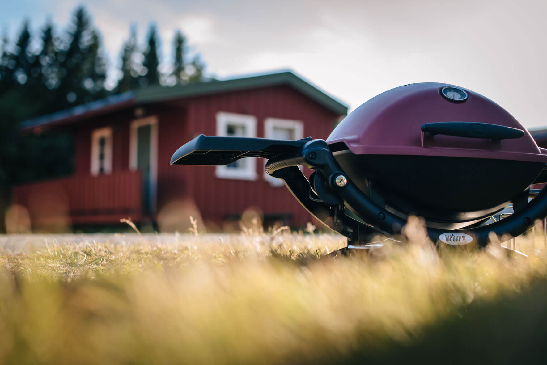 Weber Q 1200 grill with red hut on a campsite in Norway