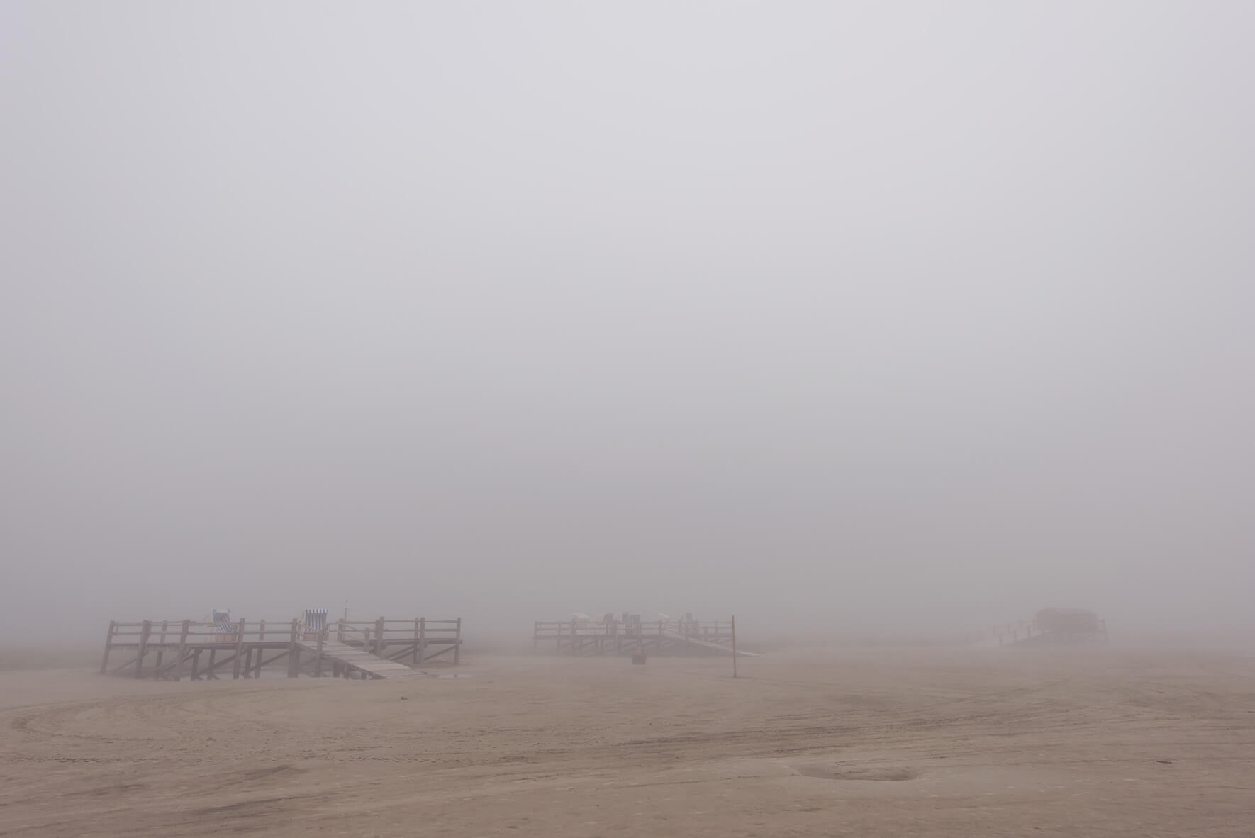 Fog over the beach of Sankt Peter-Ording with beach chairs