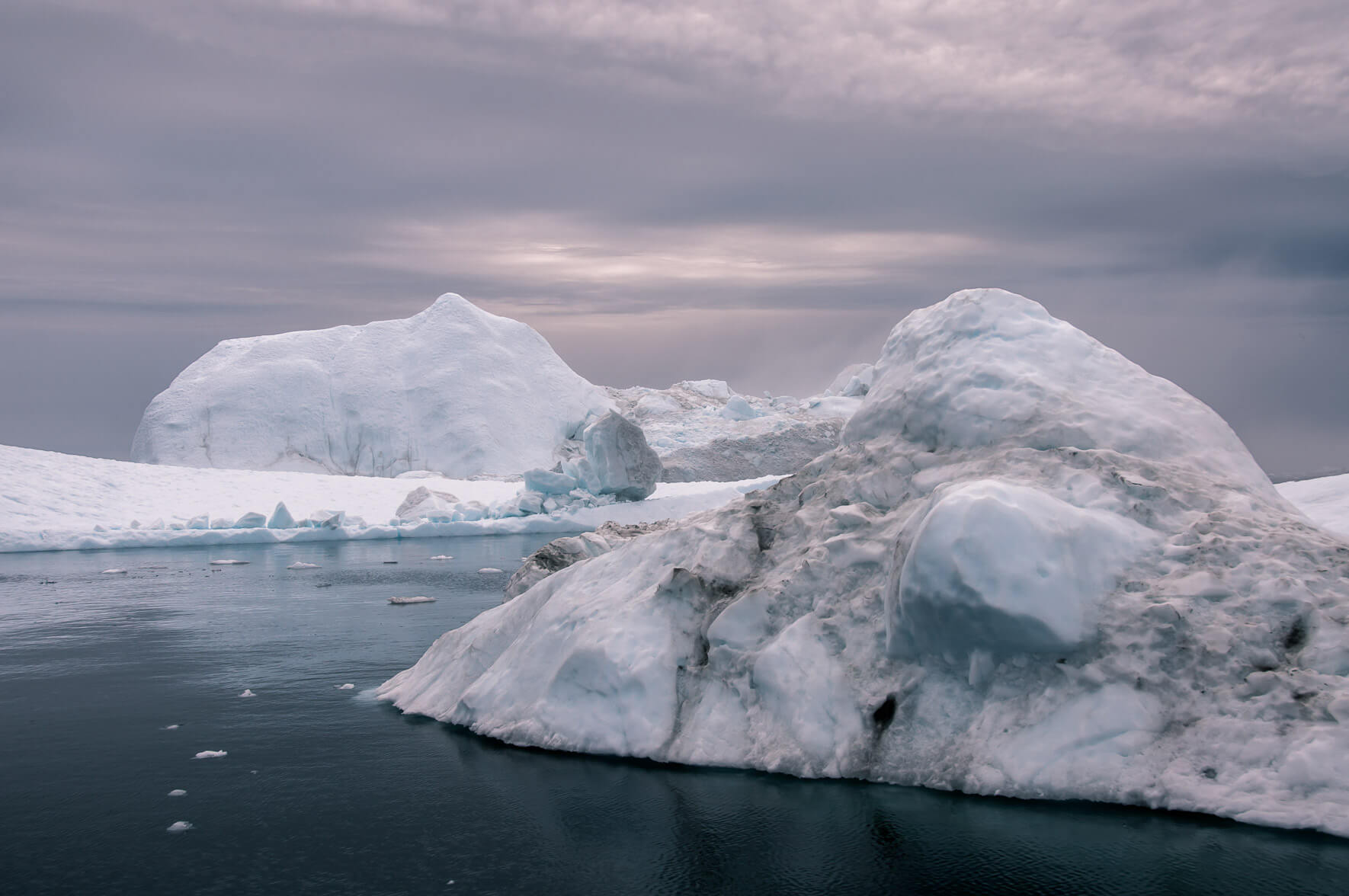 Arctic landscape with icebergs and dark water