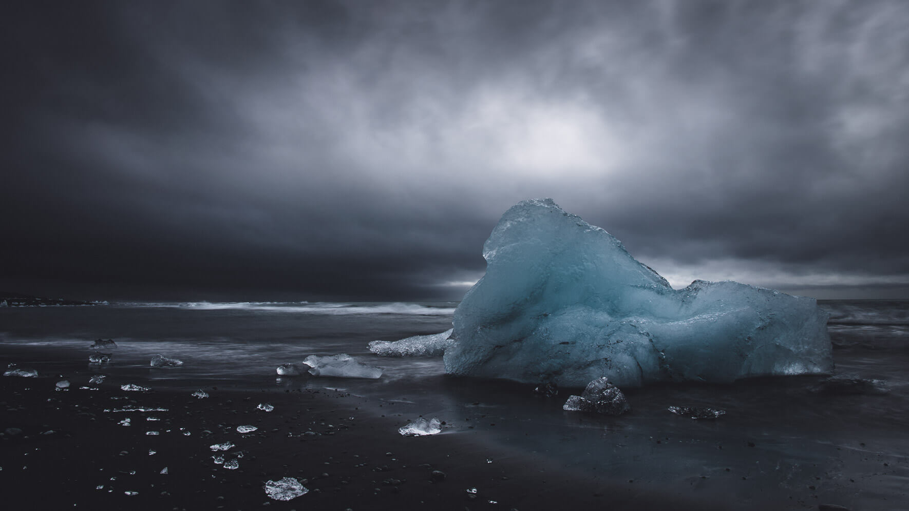 Dark clouds over iceberg on the beach of the Jökulsárlón Glacier Lagoon